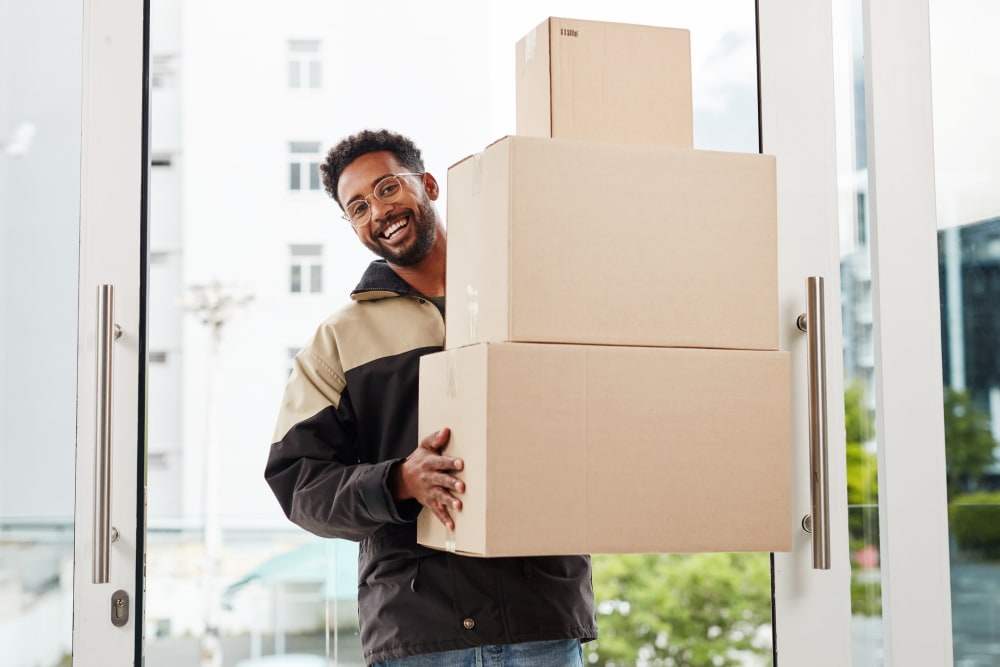 Man carrying a stack of boxes at A-American Self Storage