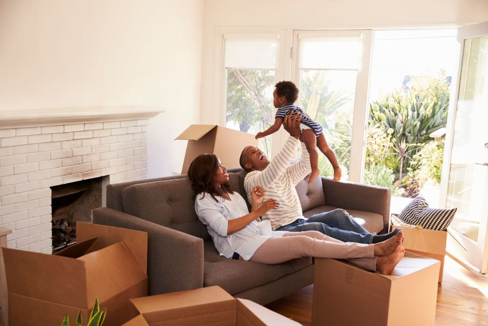 A young family takes a break from packing to play near Our Self Storage. 