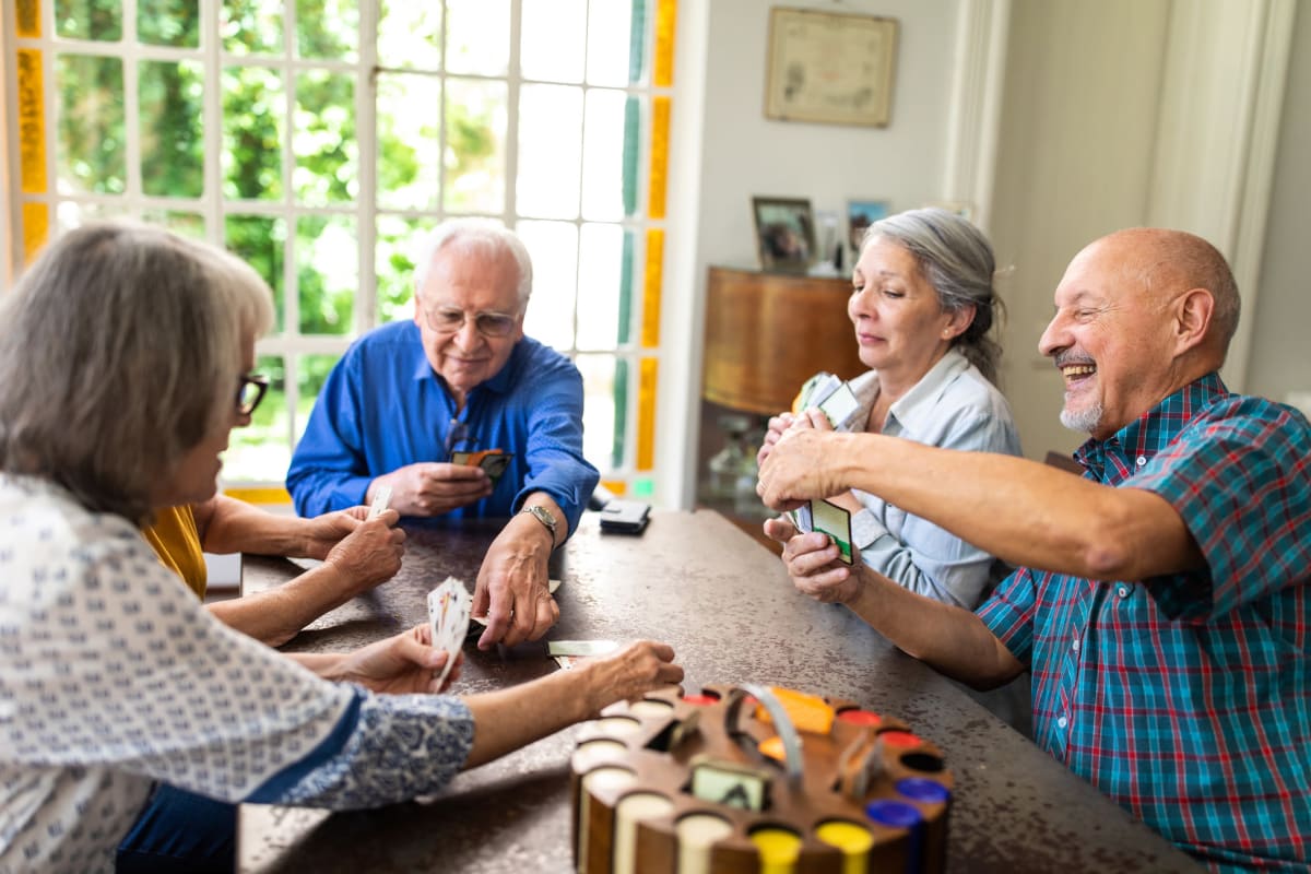 Residents laughing and playing a game at CERTUS Premier Memory Care Living in Orlando, Florida.