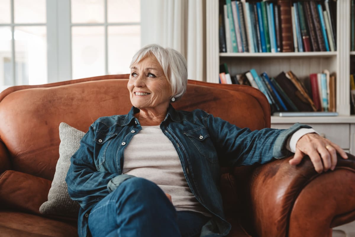 A resident sitting in a large leather chair at Oxford Villa Active Senior Apartments in Wichita, Kansas