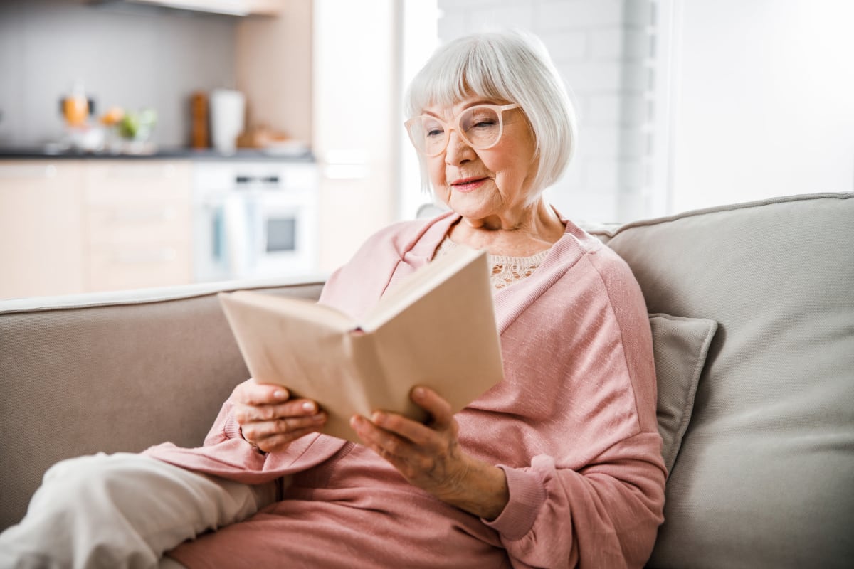 A resident reading a book at Oxford Springs Weatherford in Weatherford, Oklahoma