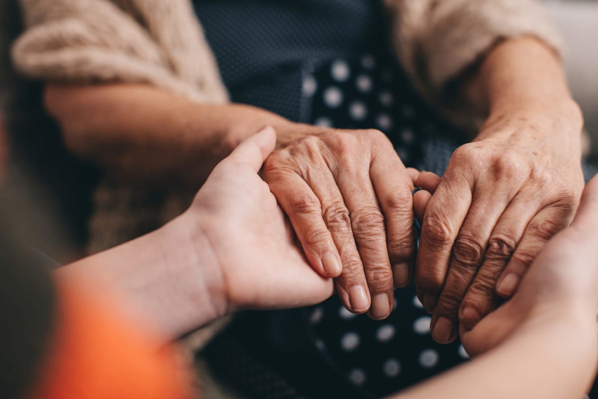 A resident holding hands with a caregiver at Oxford Glen Memory Care at Owasso in Owasso, Oklahoma