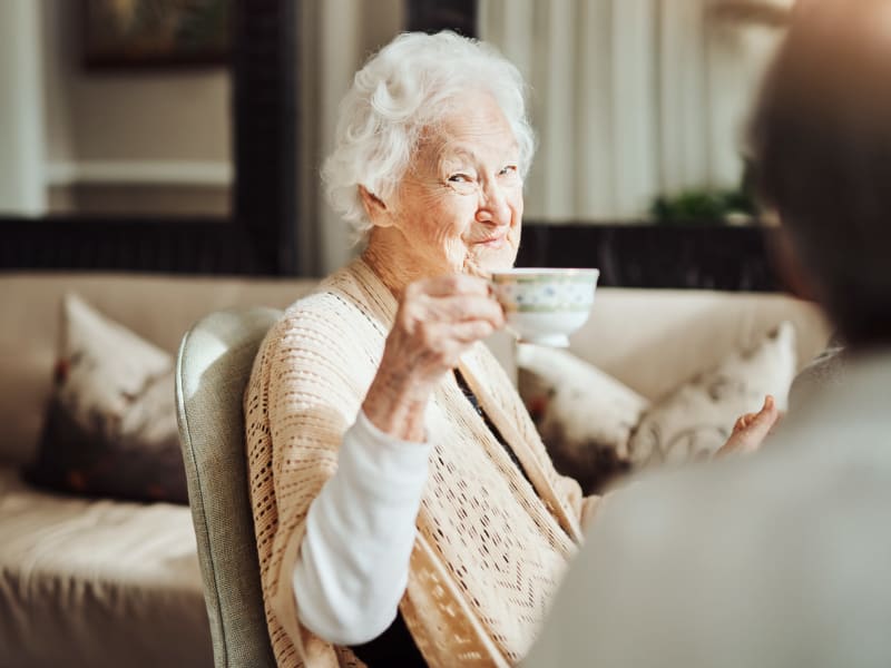 Resident holding up a cup of tea and smiling at Ingleside Communities in Mount Horeb, Wisconsin