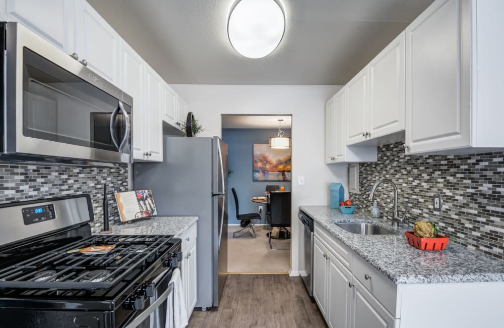 Modern kitchen with stainless steel appliances and tile backsplash at Avery Park Apartment Homes in Silver Spring, Maryland