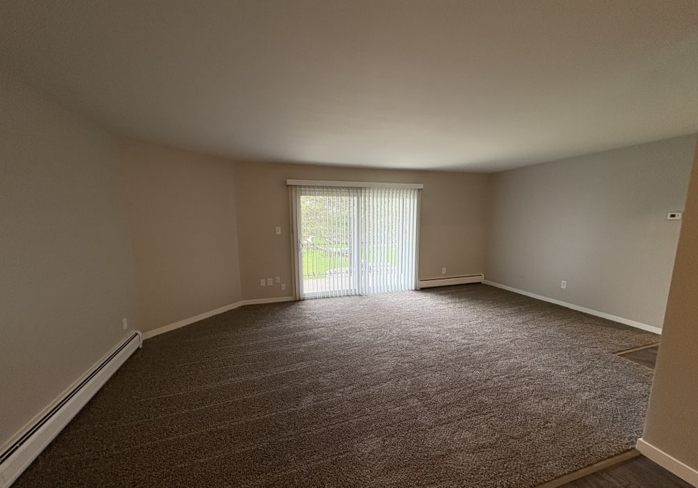 Unfurnished living room having carpet flooring at Broadway Crossing Apartments in Merrillville, Indiana