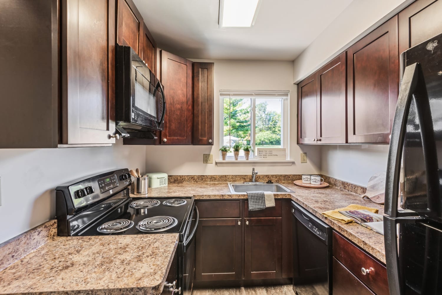 Kitchen with sleek black appliances at Penbrooke Meadows in Penfield, New York