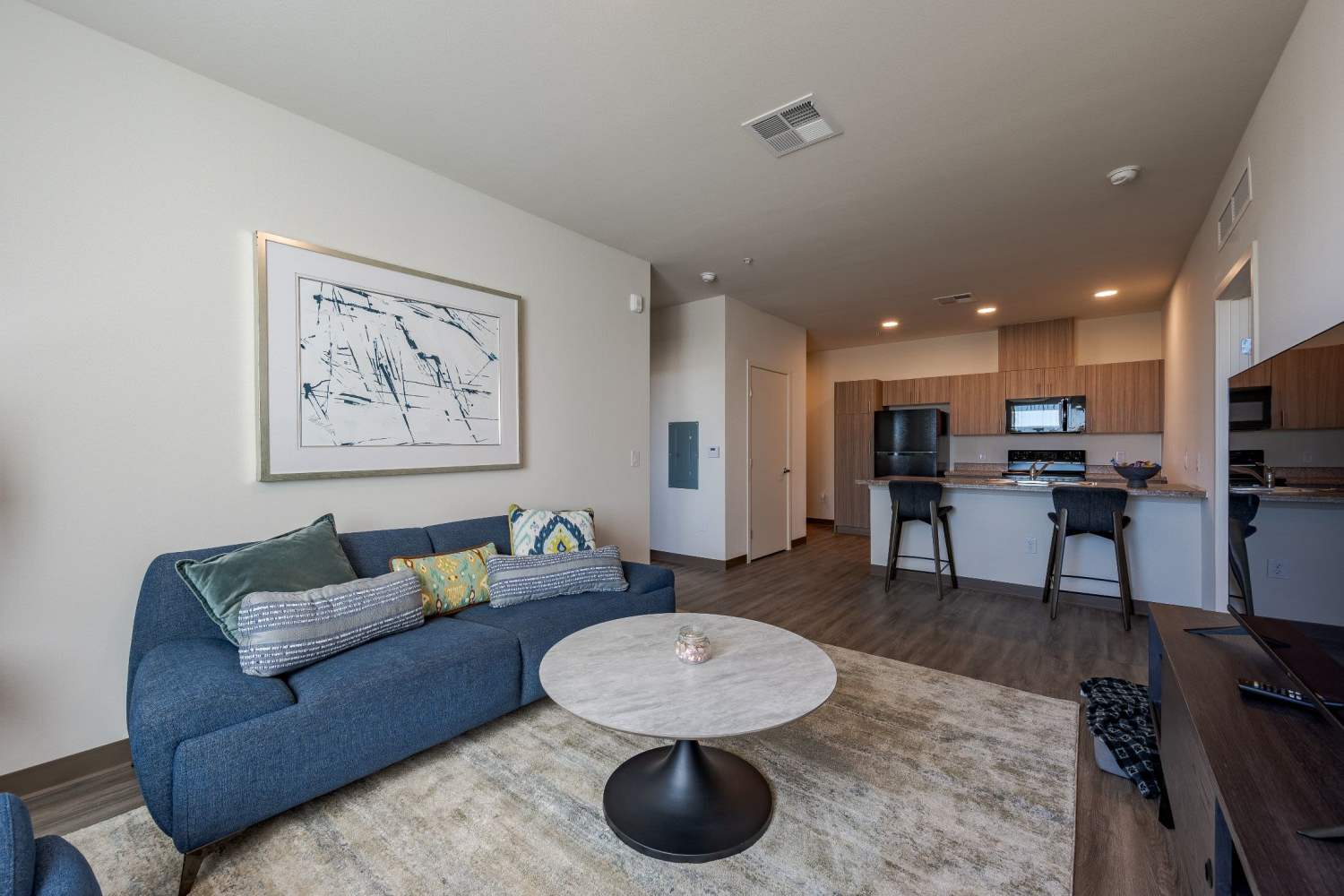 Living room with hardwood floors near the kitchen at Overland Flats in Maricopa, Arizona