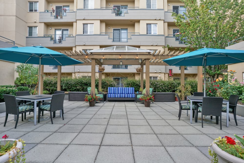 Exterior courtyard with umbrella seating at Island House in Mercer Island, Washington