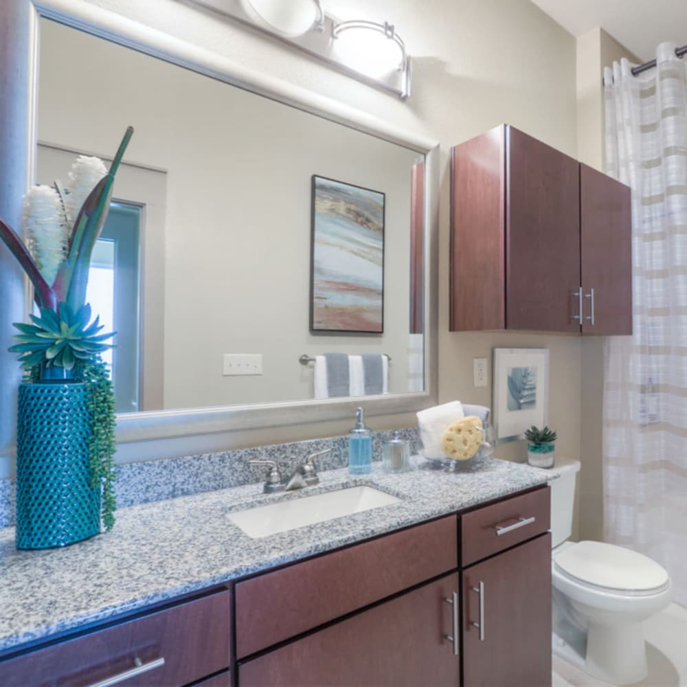 Model bathroom with an oversized vanity and granite countertops at Imperial Lofts in Sugar Land, Texas