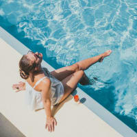 Resident lounging by a Campus Life & Style swimming pool