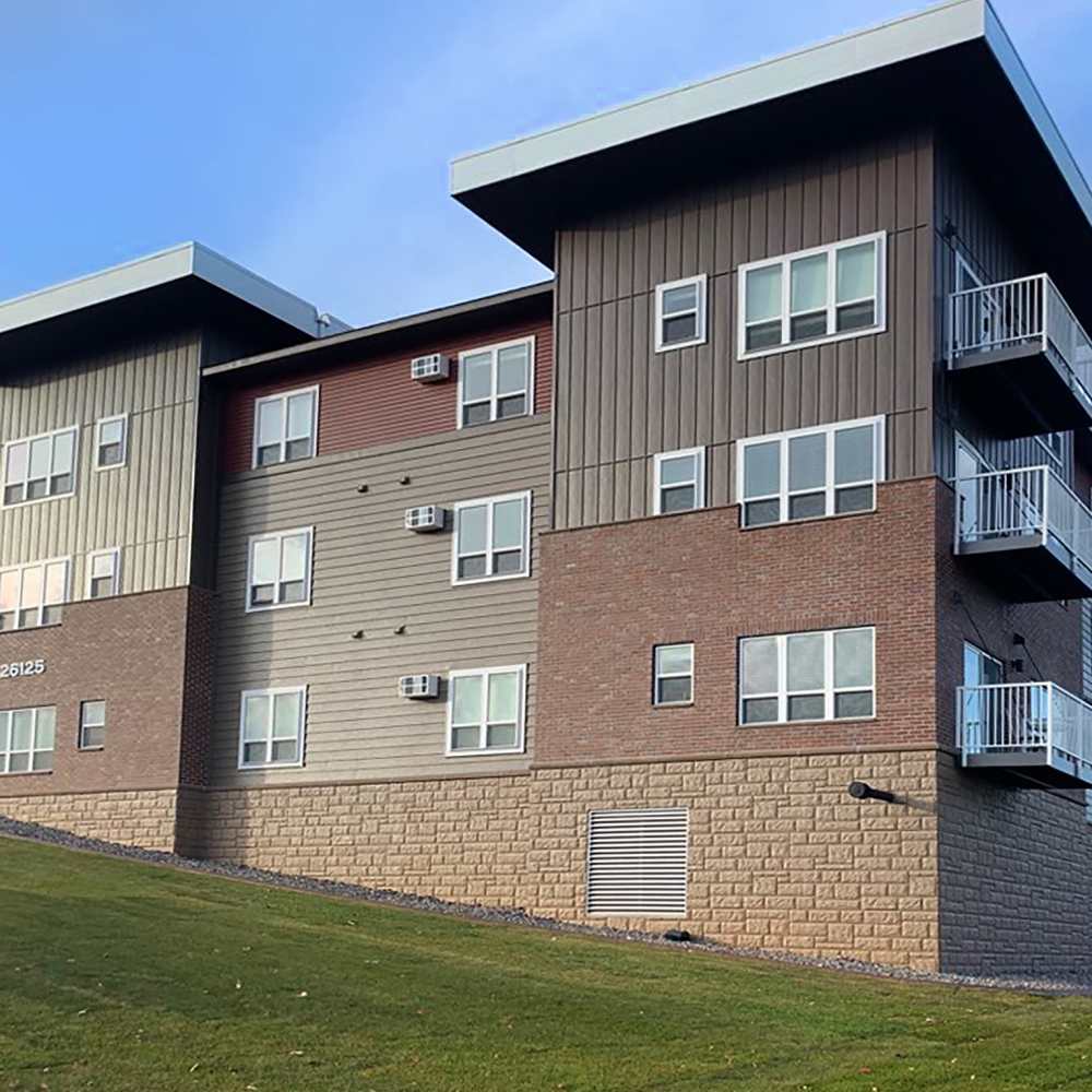 Apartment exterior view with green lawn at Depot on Main in Zimmerman, Minnesota