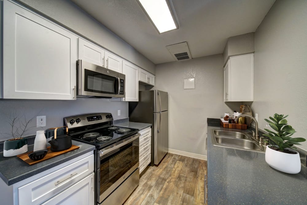 A kitchen with plenty of cabinet space at Parkside Commons Apartments in San Leandro, California