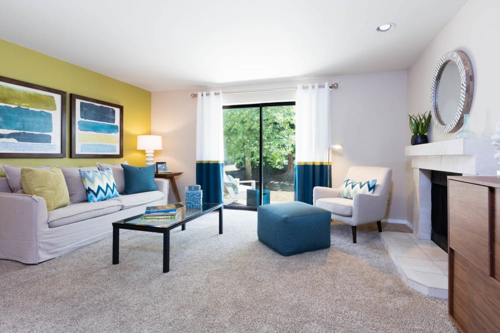 Large living room with plush carpet in a model home at Madison Sammamish Apartments in Sammamish, Washington