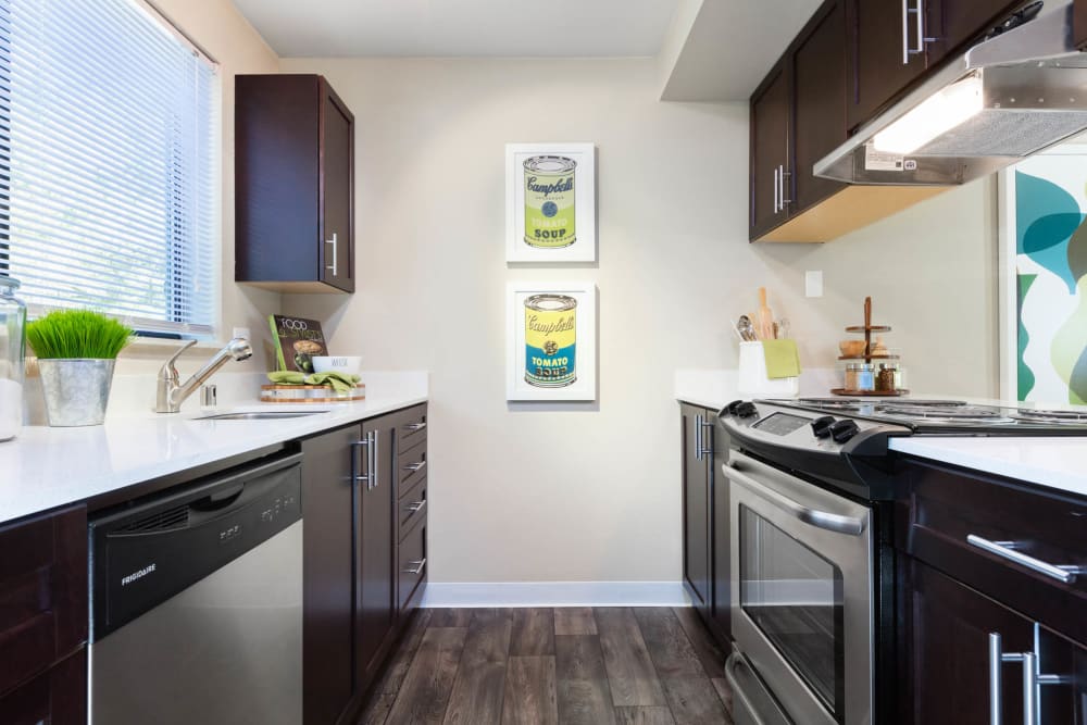 Modern kitchen with quartz countertops and stainless-steel appliances in a model home at Madison Sammamish Apartments in Sammamish, Washington