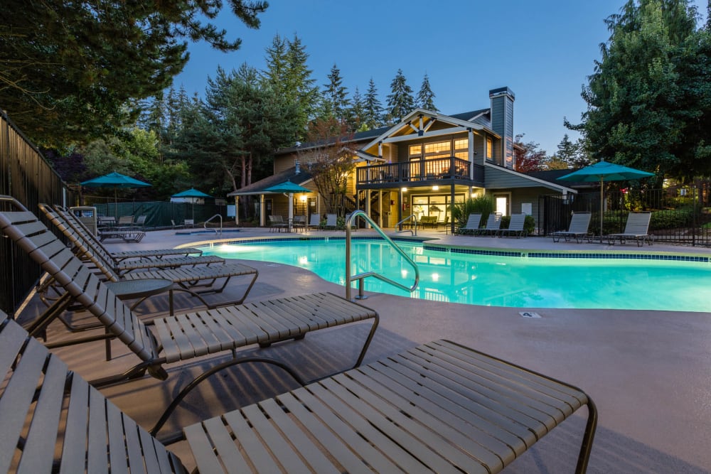 Large pool with pool side chairs at Madison Sammamish Apartments in Sammamish, Washington