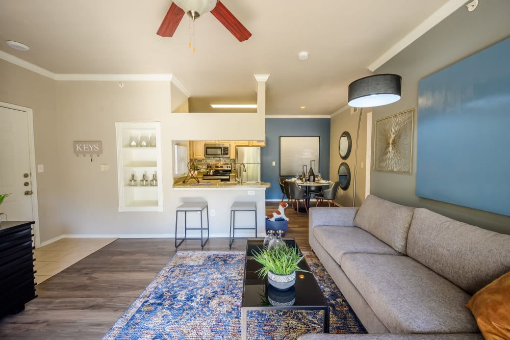 Open-concept model home's living area with a ceiling fan and hardwood flooring at 23Hundred @ Ridgeview in Plano, Texas