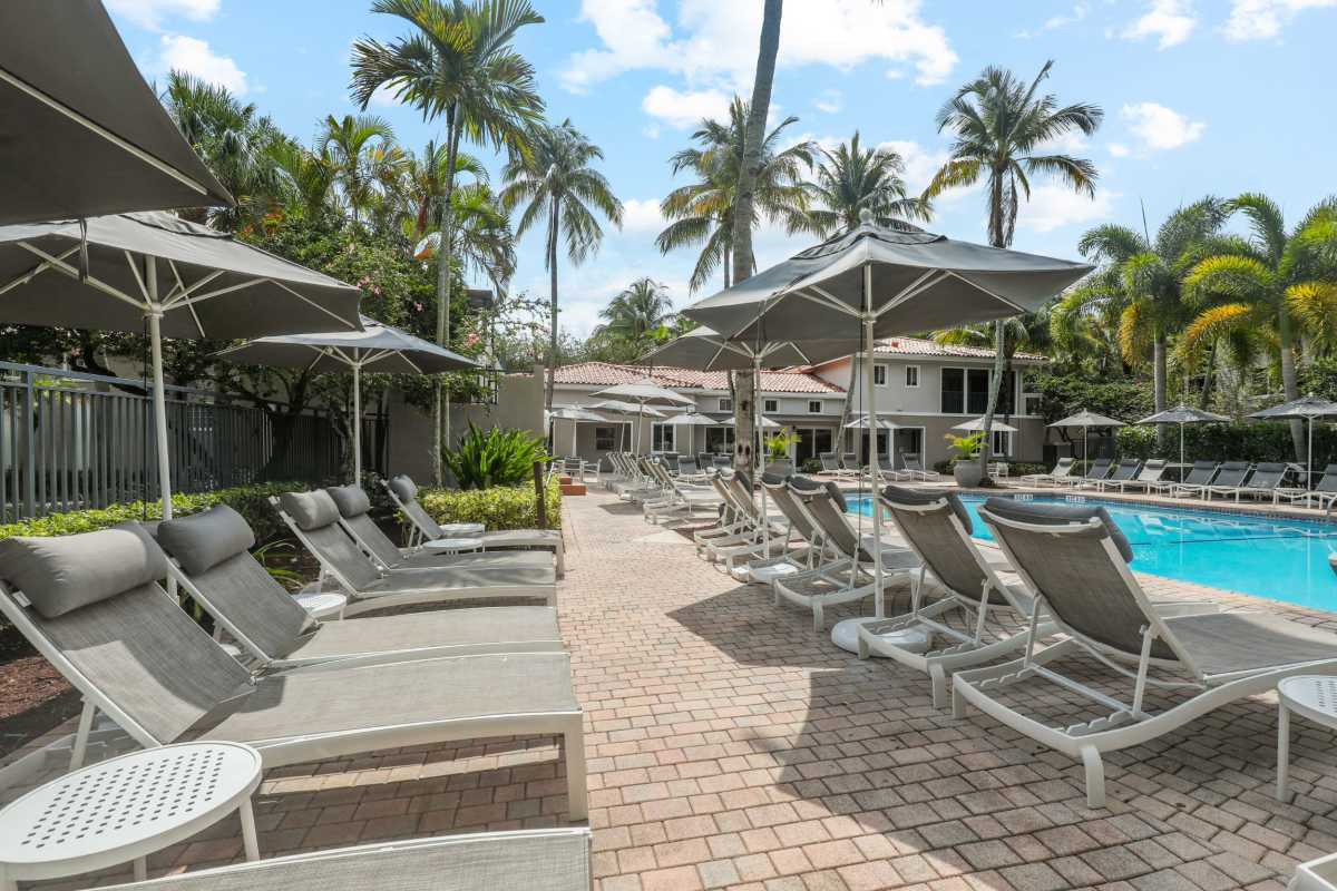 Pool patio with lounge chairs at Coconut Palm Club, Coconut Creek, Florida