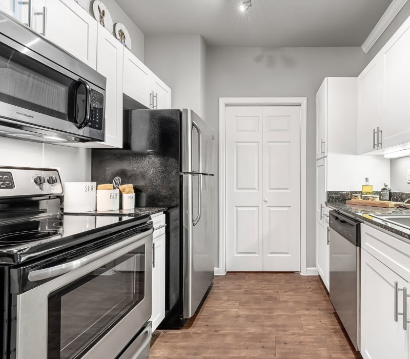 Kitchen with stainless steel appliances and laundry closet at Marquis at Texas Street in Dallas, Texas