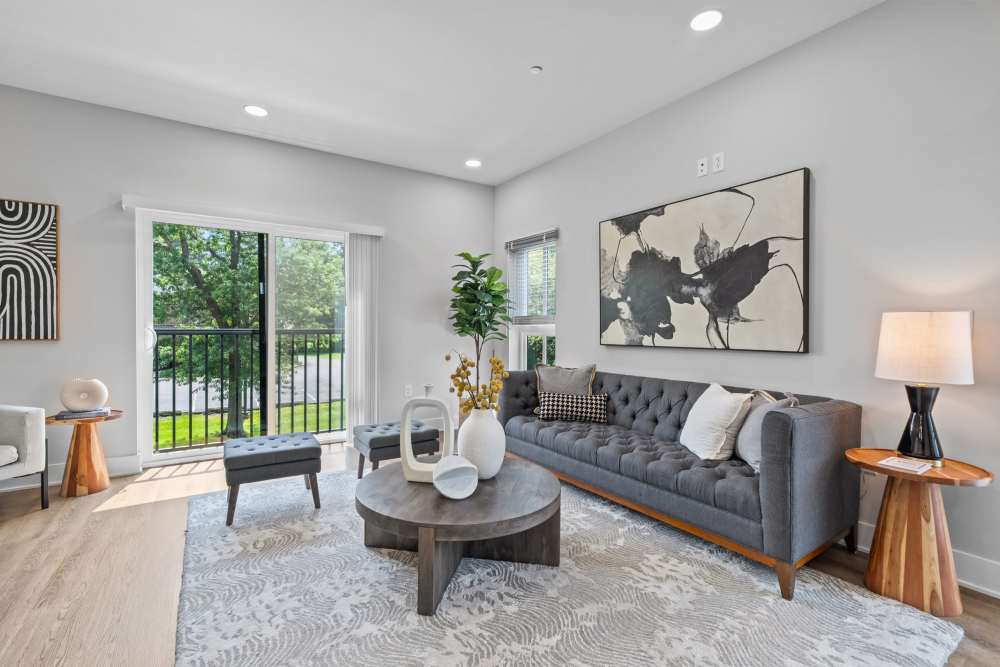 A modern living room featuring gray furniture and a large abstract painting on the wall at Landmark at Dublin in Dublin, Pennsylvania