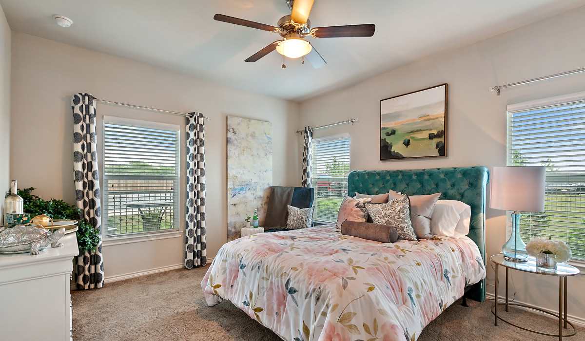 Comfortable bedroom with king size bed, ceiling fan and windows at Canyon House in New Braunfels, Texas