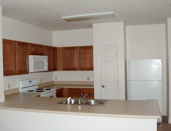Kitchen room with white appliances at Journet Place in Port Richey, Florida
