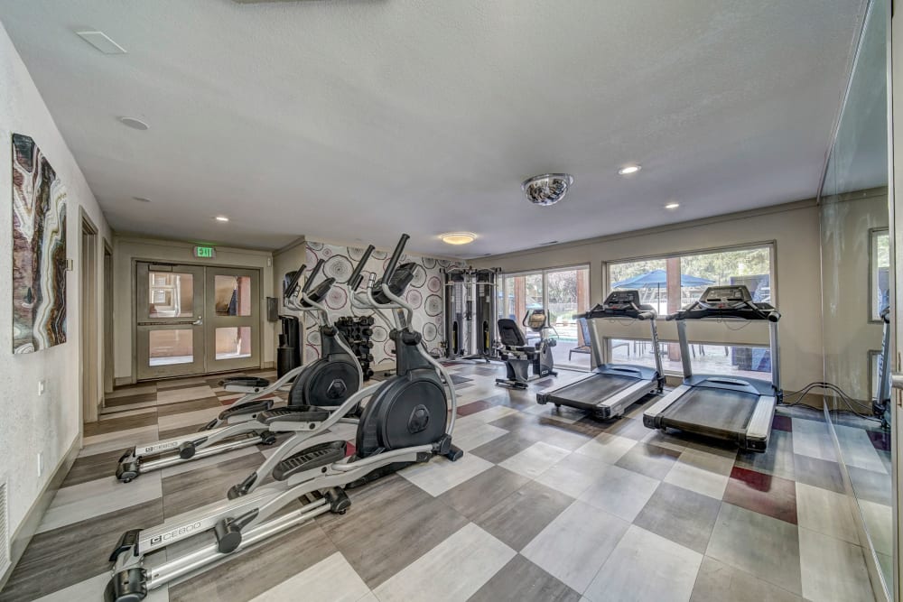 Fitness center with plenty of individual workout stations at The Timbers Apartments in Hayward, California