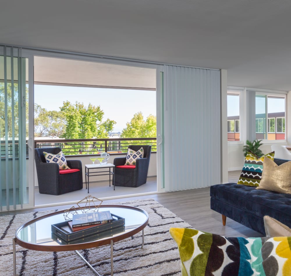 View of the well-decorated private balcony outside a model home's living room at Sofi Belmont Glen in Belmont, California