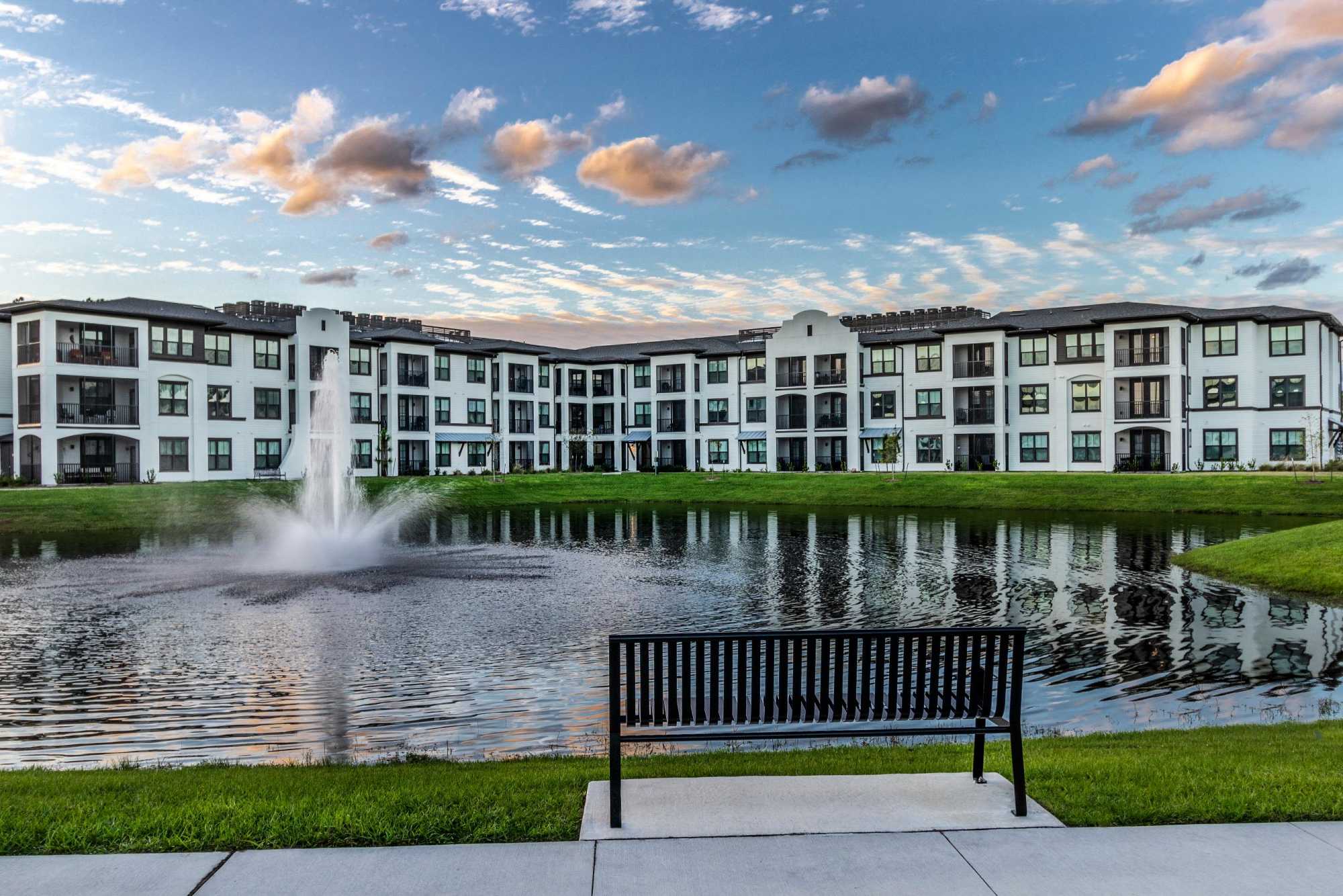 Apartment community view with pond, fountain, and bench at Brisa at St. Augustine in St. Augustine, Florida