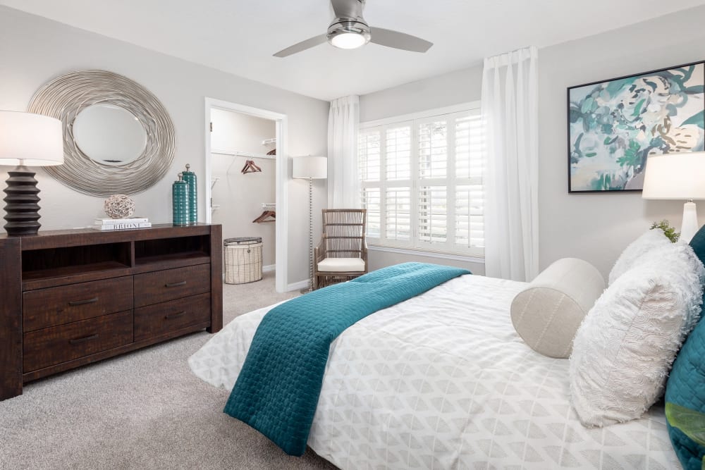 Model home's primary bedroom with a ceiling fan and plush carpeting at Amira at Westly in Tampa, Florida