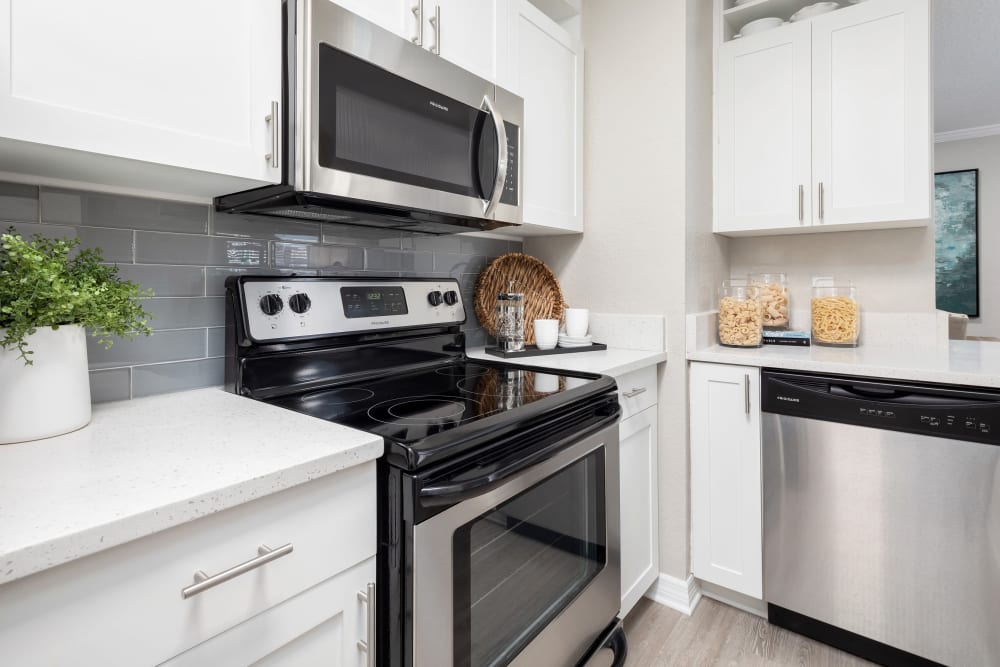 Stainless-steel appliances and white cabinetry in a model home's kitchen at Amira at Westly in Tampa, Florida