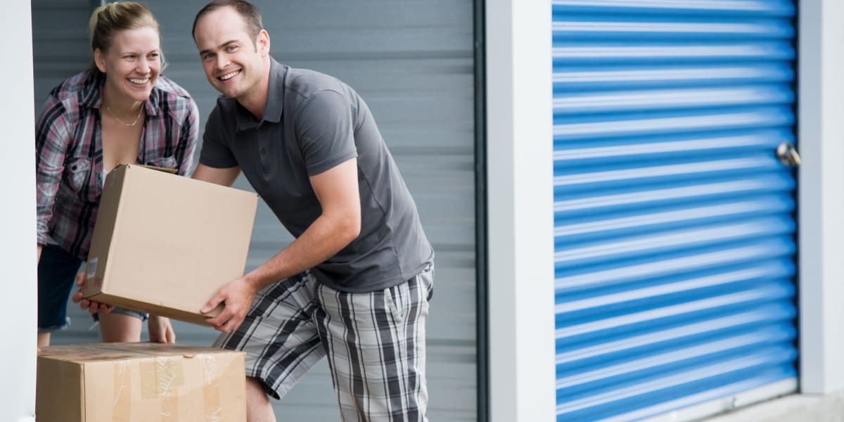 A couple loading boxes into a storage unit at Airport Self Storage in Salem, Oregon