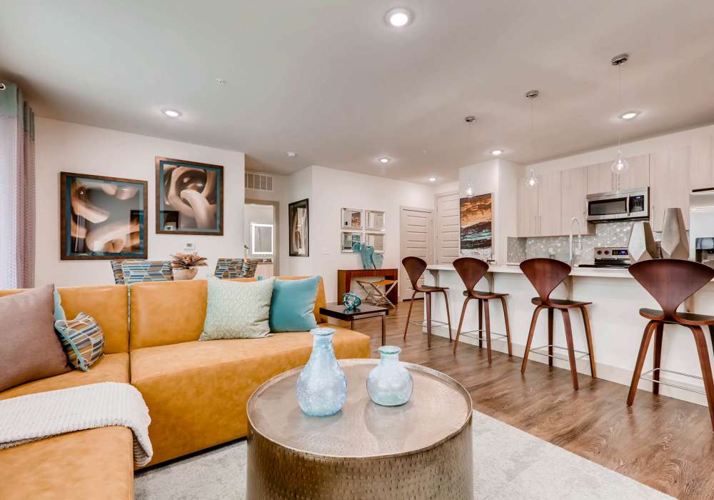 Stylish living room with access to kitchen area at Station A Apartments in Denver, Colorado