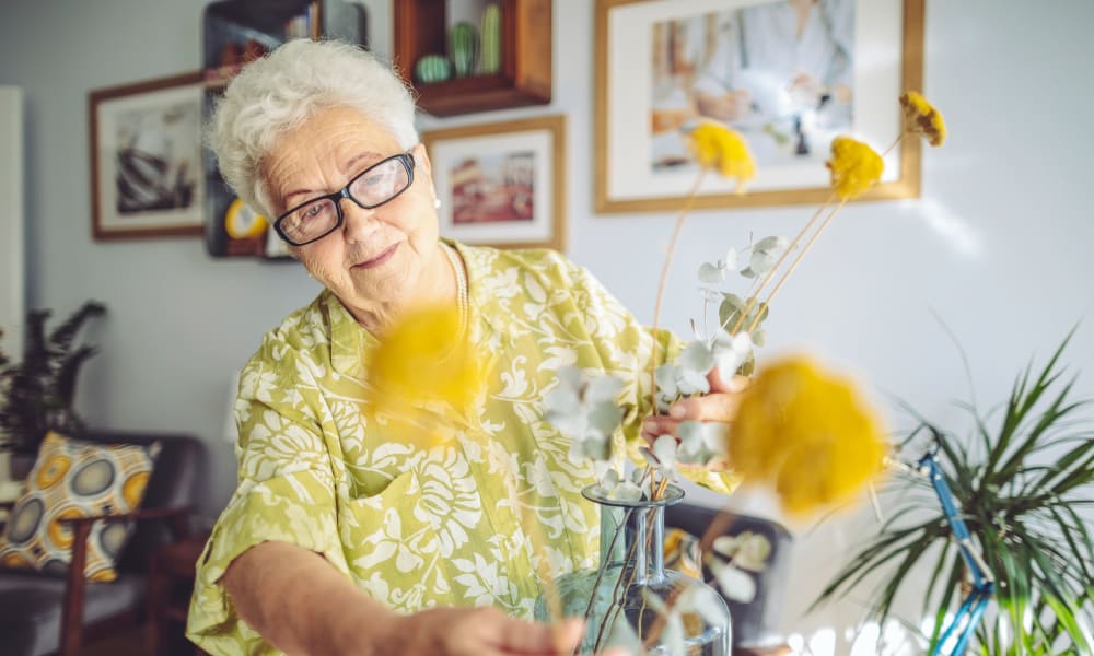 Resident arranging flowers in a vase at Randall Residence of Fremont in Fremont, Ohio