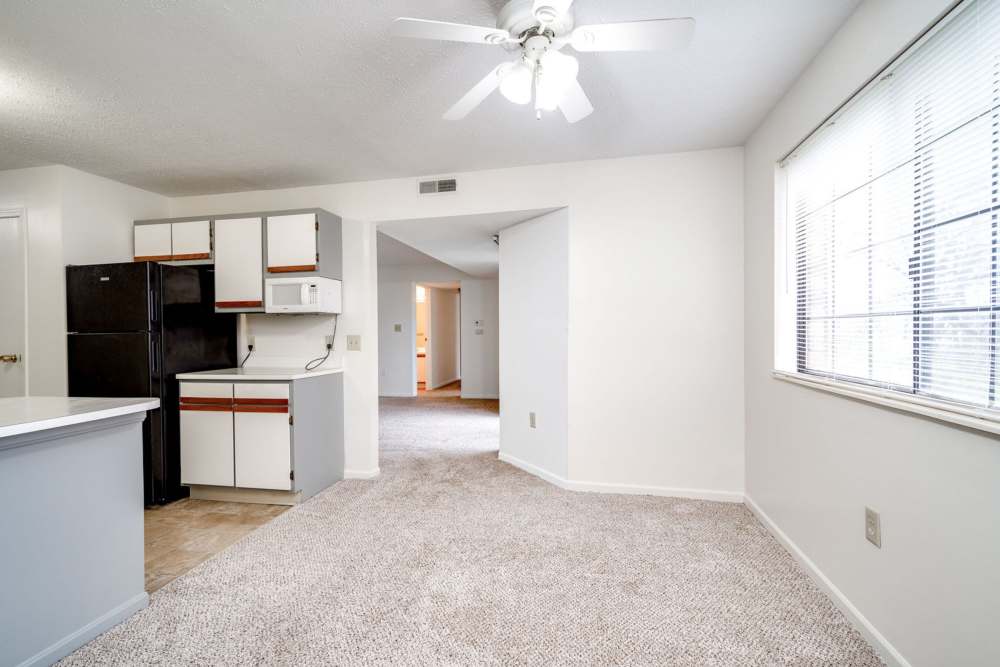 Modern kitchen with appliances and living area at Carriage Court in Cincinnati, Ohio