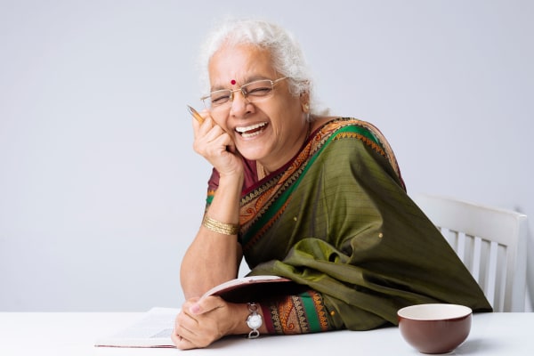 Lady sitting at table with a tea cup laughing at The Phoenix at Estero in Estero, Florida