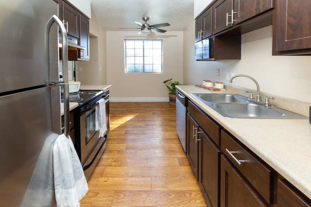 Kitchen with stainless-steel appliances and wood cabinet at Royal Ridge Apartments in Midvale, Utah