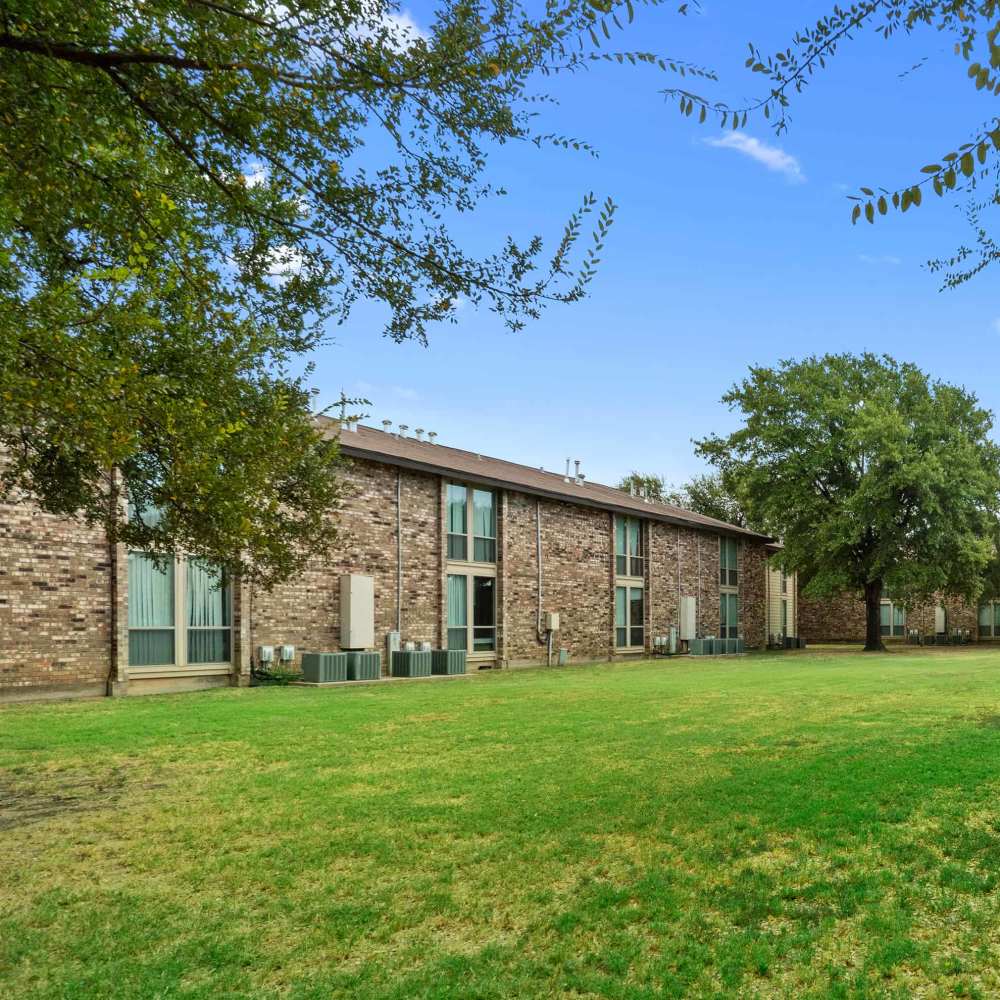 Beautiful exterior view of the apartment with lush green at Woodland Village Apartments in Breckenridge, Texas
