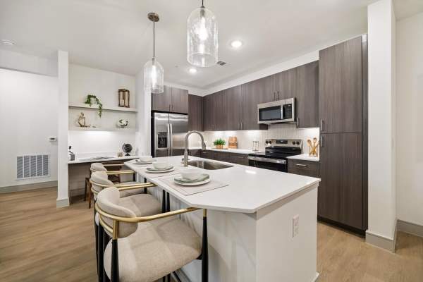 Luxury modern kitchen with island and bar stools at Dakota at Hillcroft in Houston, Texas