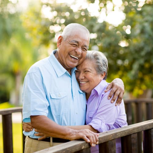 Resident couple hugging outside at The Heritage Memory Care in The Woodlands, Texas
