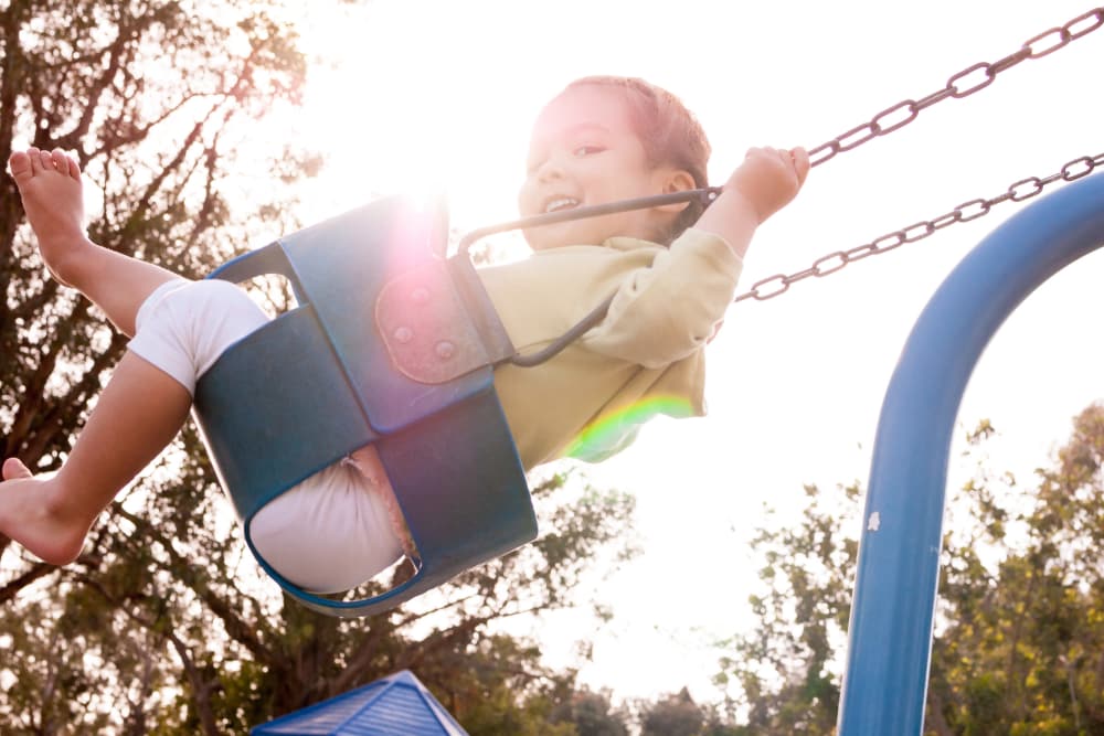 Children swinging at the park near McKinnon Apartments in Sacramento, California