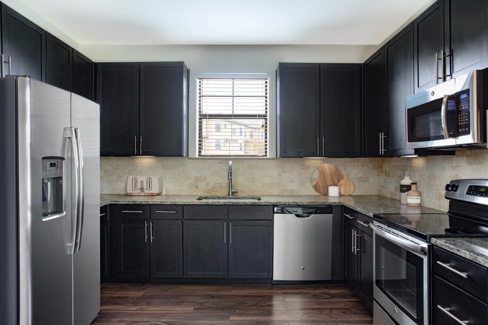 Large open kitchen with stainless steel appliances at Olympus Falcon Landing in Katy, Texas