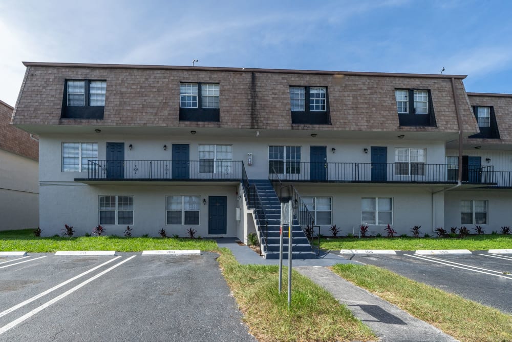 Exterior of apartment building and parking lot area at Piper Village West in West Palm Beach, Florida