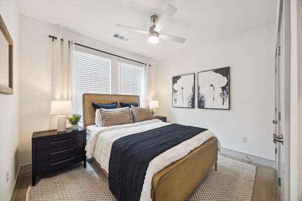 Bed with modern bedding and decorative pillows at Dakota at Hillcroft in Houston, Texas