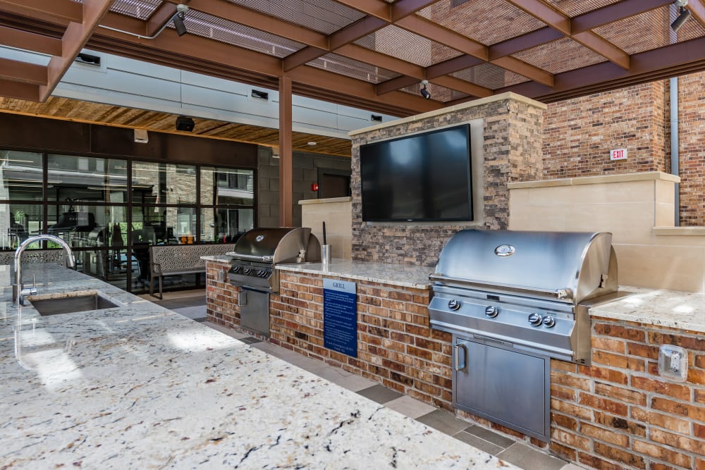 Outdoor kitchen area with multiple grills available at Anthology of Tanglewood in Houston, Texas