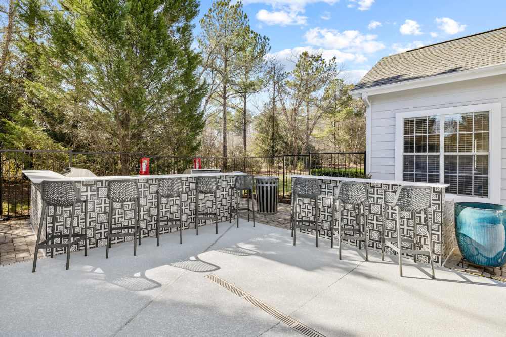 Outdoor dining area near grilling stations at The Waterford in Morrisville, North Carolina