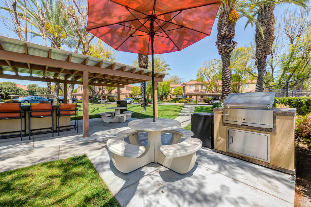 Outdoor barbecue and picnic area at Tuscany Village Apartments in Ontario, California