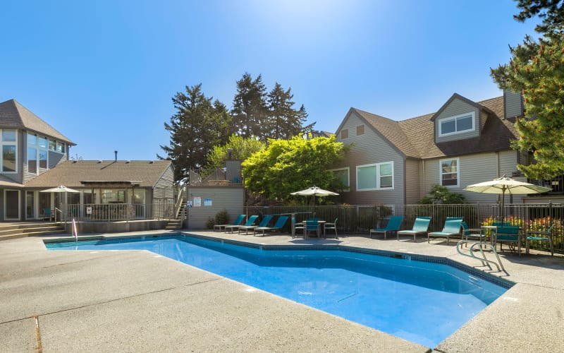 Lounge chairs on the poolside deck at Meadows at Cascade Park Apartments in Vancouver, Washington