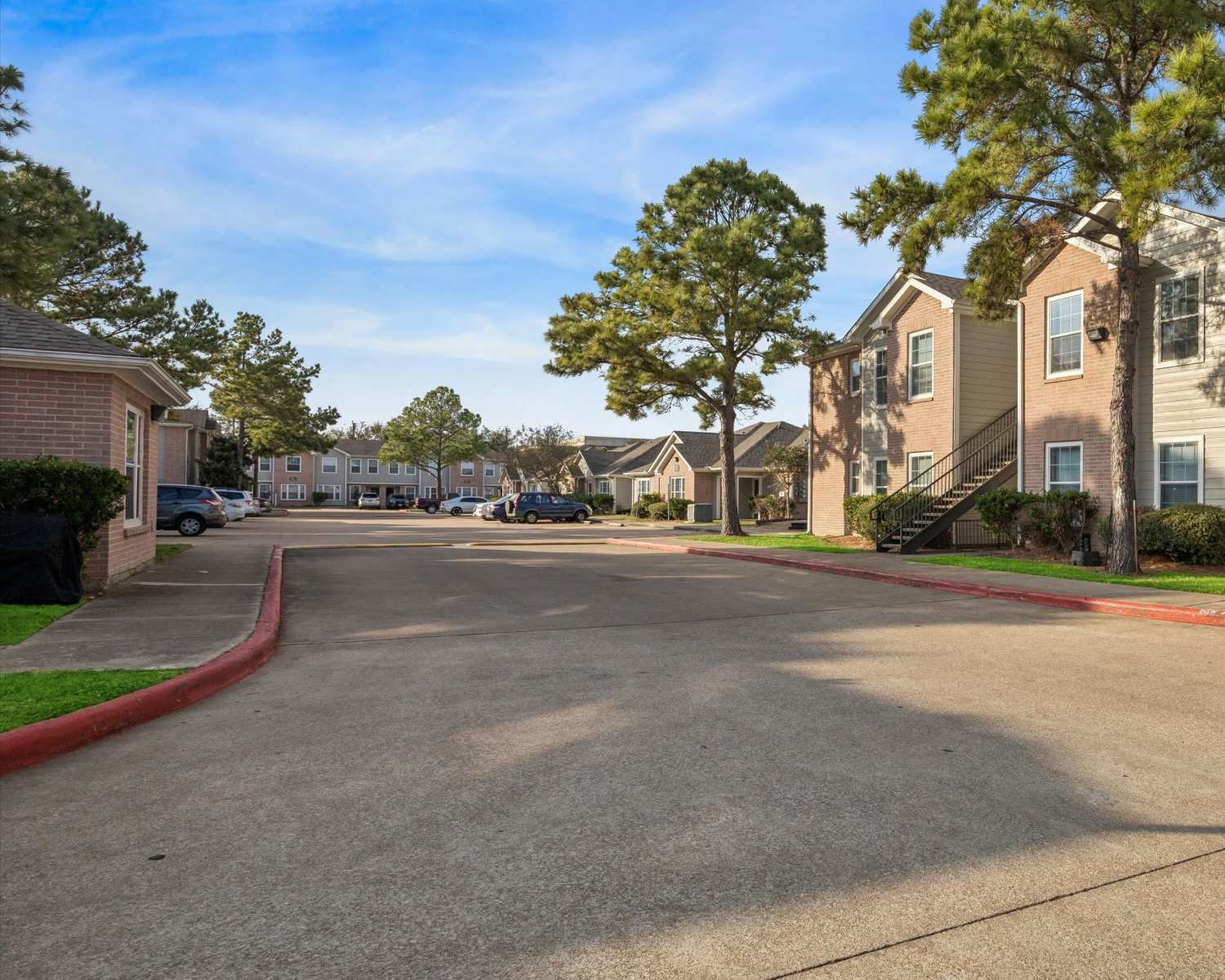 Charming apartment community with lush landscaping and inviting walkways at Scott Street Townhomes in Houston, Texas.