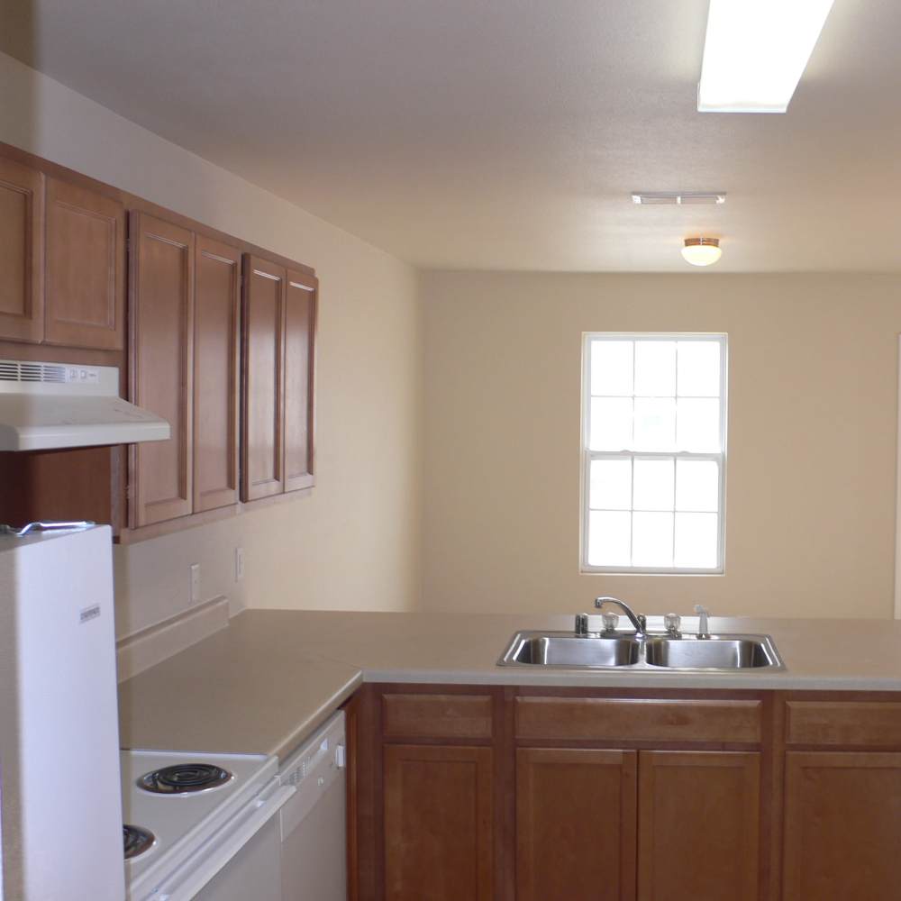 Apartment kitchen with wooden cabinets at Eagle Ridge in Hobbs, New Mexico