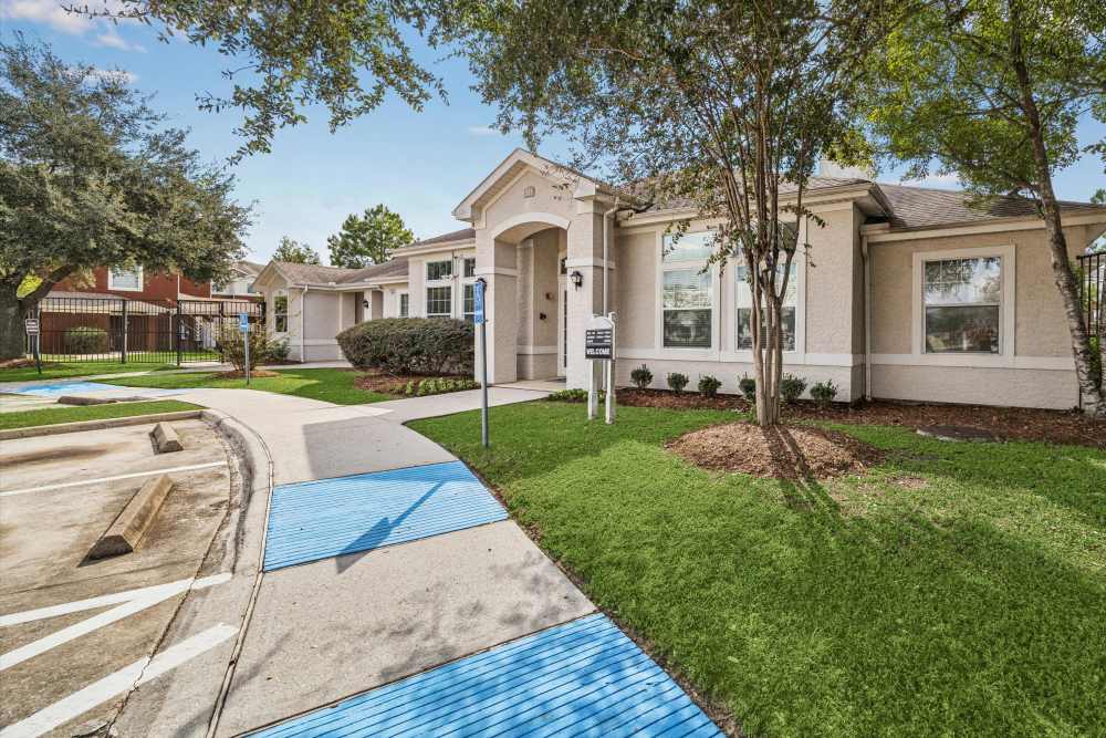 Exterior view of the apartments having lawns and walkways at Kimberly Pointe in Houston, Texas